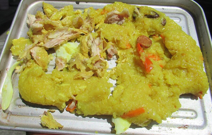Bringhe yellow turmeric rice with chicken pieces in a metal pan