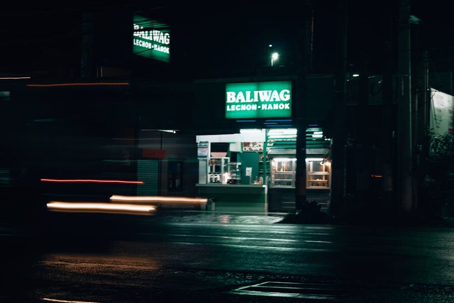 Baliwag Lechon Manok storefront at night with neon green sign
