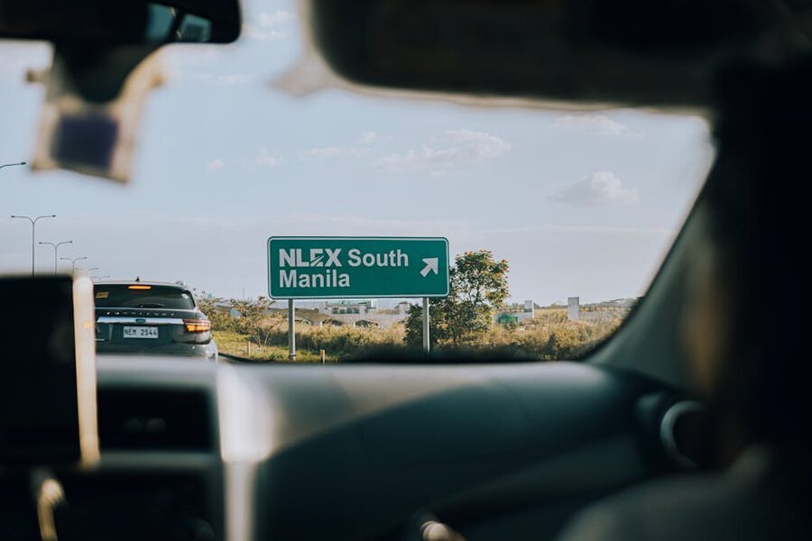 View from a car windshield with NLEX South Manila highway sign visible