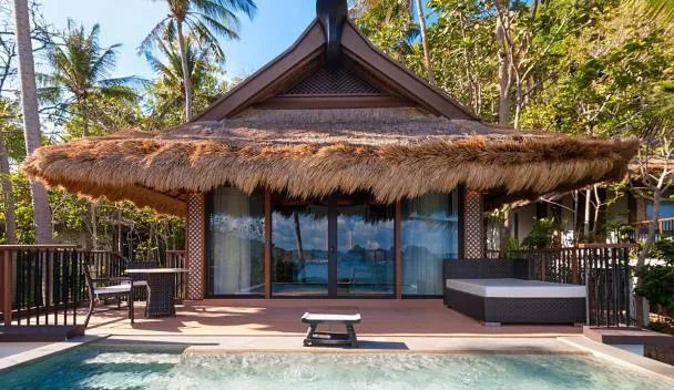 Pangulasian Island Resort villa with thatched roof and sea El Nido