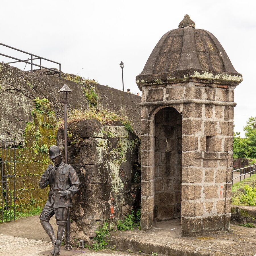 A small stone garita (sentry box) on the walls of Fort Santiago, Intramuros, with weathered stone steps and lampposts