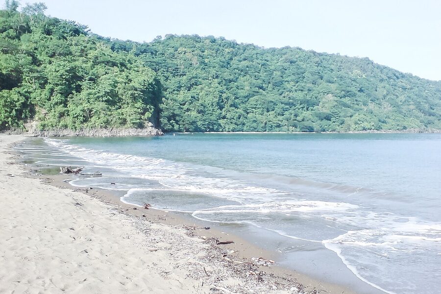Calayo Beach in Nasugbu, Batangas with grey sand and outrigger boats