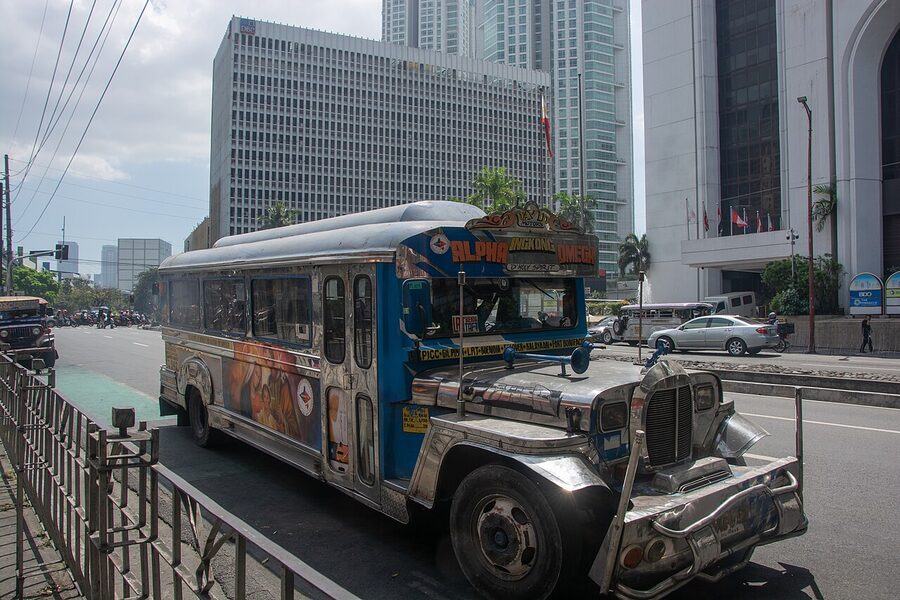 Decorated jeepney parked on a Makati street with skyscrapers in the background
