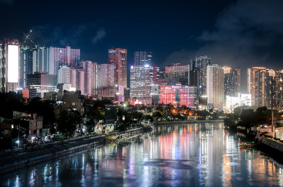 Makati skyline reflected in a river at night with neon lights