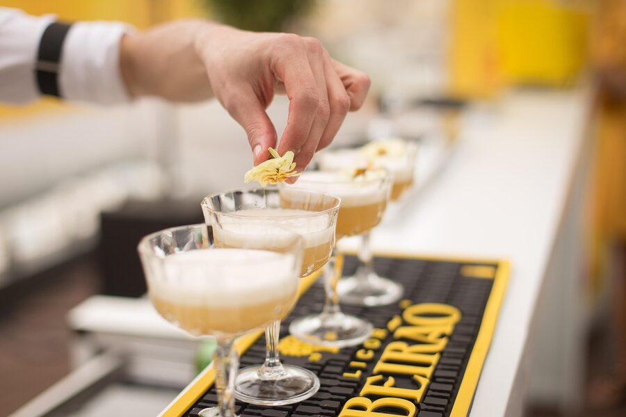 Bartender preparing colourful cocktails behind a bar counter