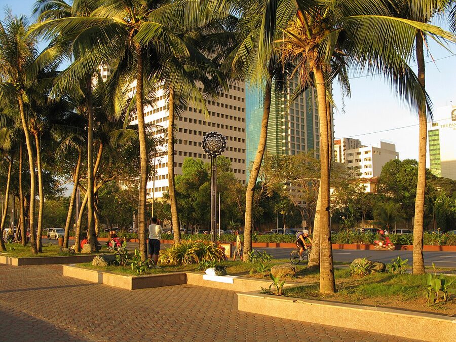Sunset over Roxas Boulevard with Manila Bay and palm trees