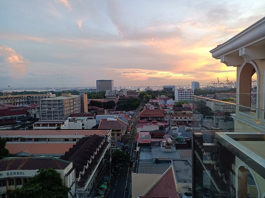 Sunset view from a rooftop terrace overlooking Intramuros and Manila harbour