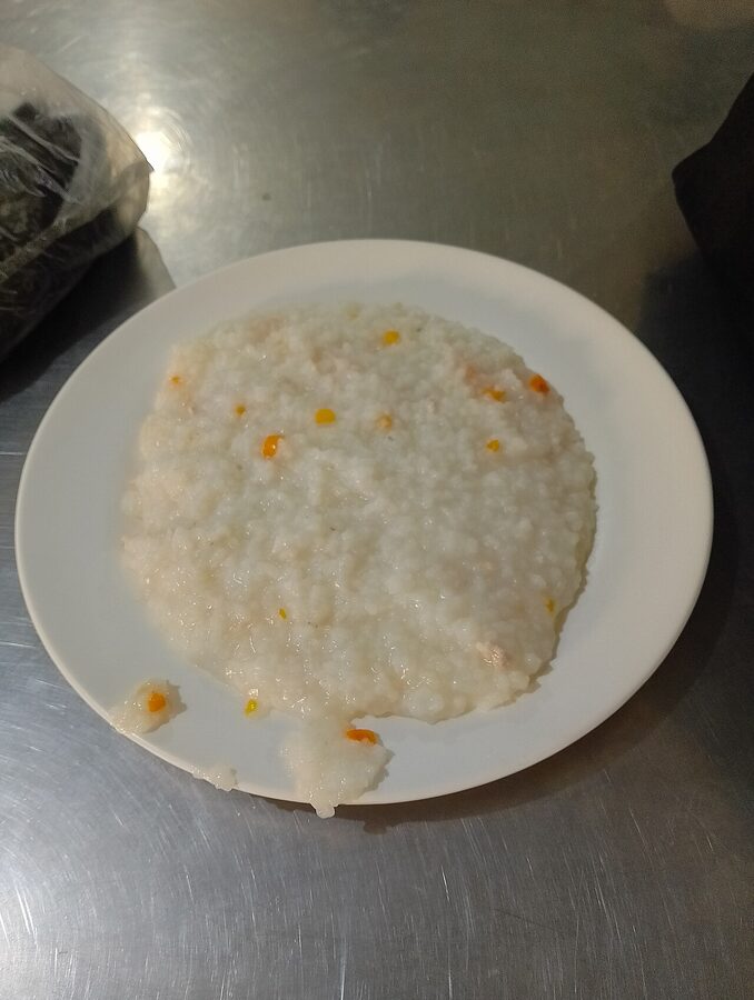 A bowl of Filipino lugaw rice porridge with garlic and chicharon on top