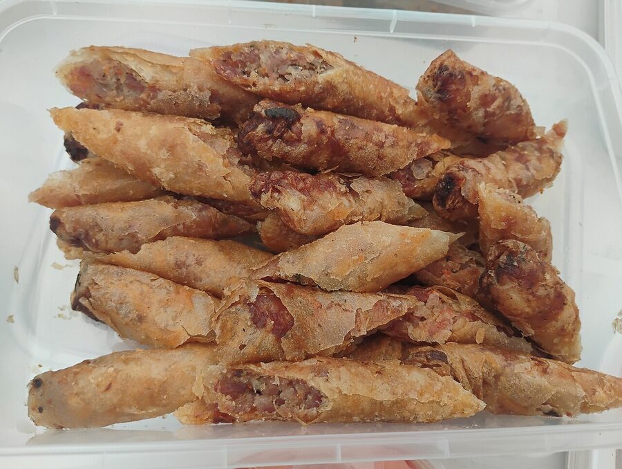 Plate of crispy lumpiang shanghai Filipino spring rolls with dipping sauces