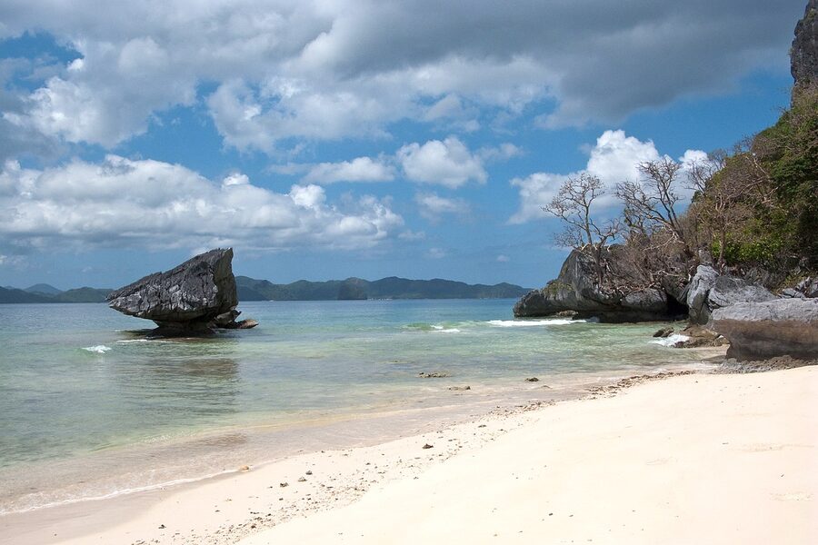 Distinctive limestone rock formation on the Corong Corong beach in El Nido at low tide with white sand
