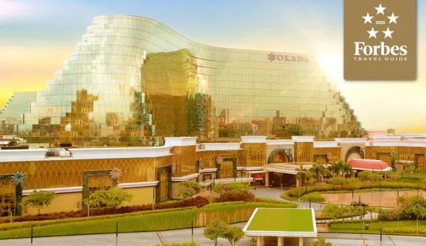Okada Manila exterior at sunset showing the curved twin tower and circular driveway