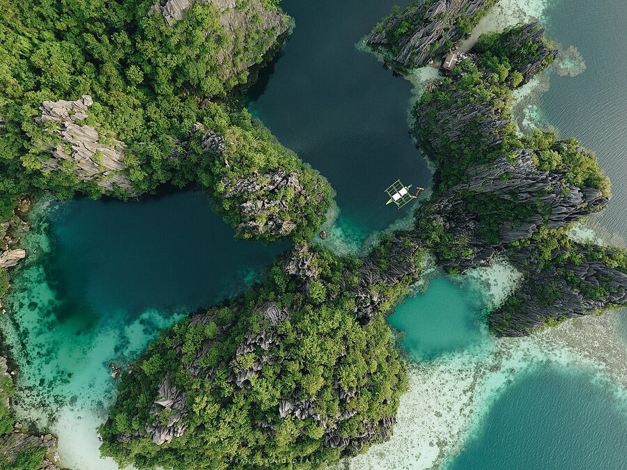 Aerial view of the Twin Lagoon area connecting two turquoise pools through limestone in El Nido area