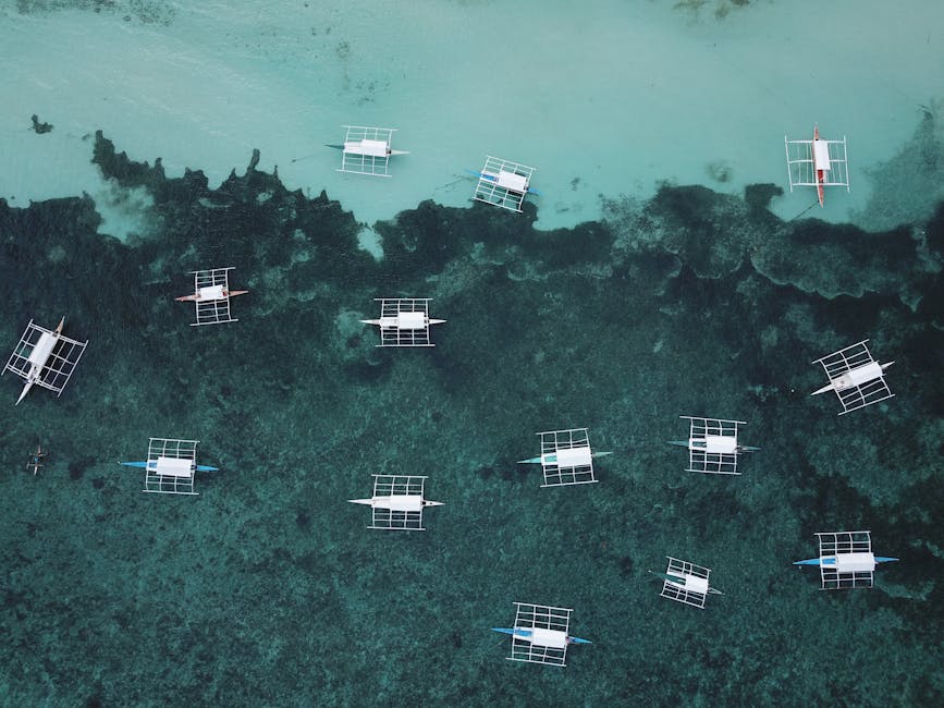 Aerial view of outrigger boats on turquoise reef in Central Visayas