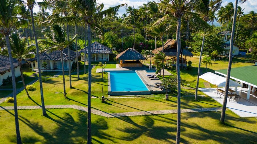 Aerial view of a tropical resort pool surrounded by lush greenery in the Philippines