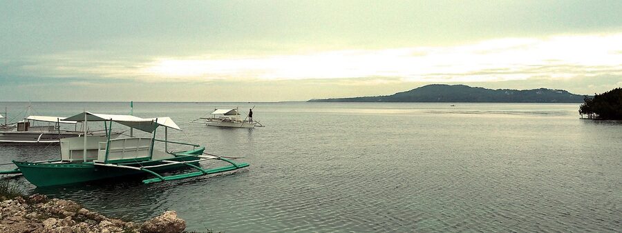 Outrigger boat at sunrise off Bohol coast