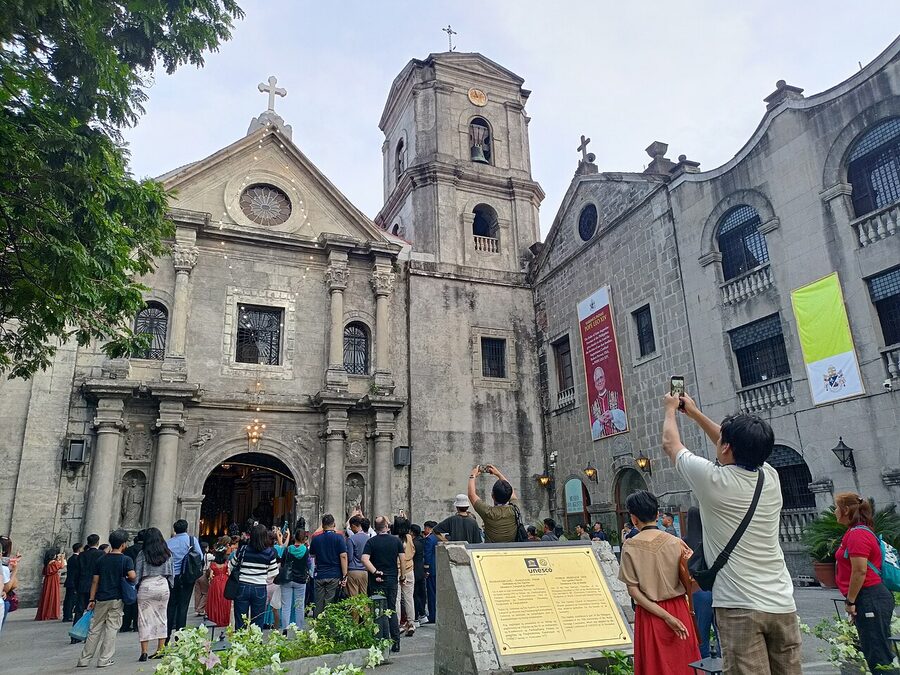 San Agustin Church facade in Intramuros with crowd outside the entrance