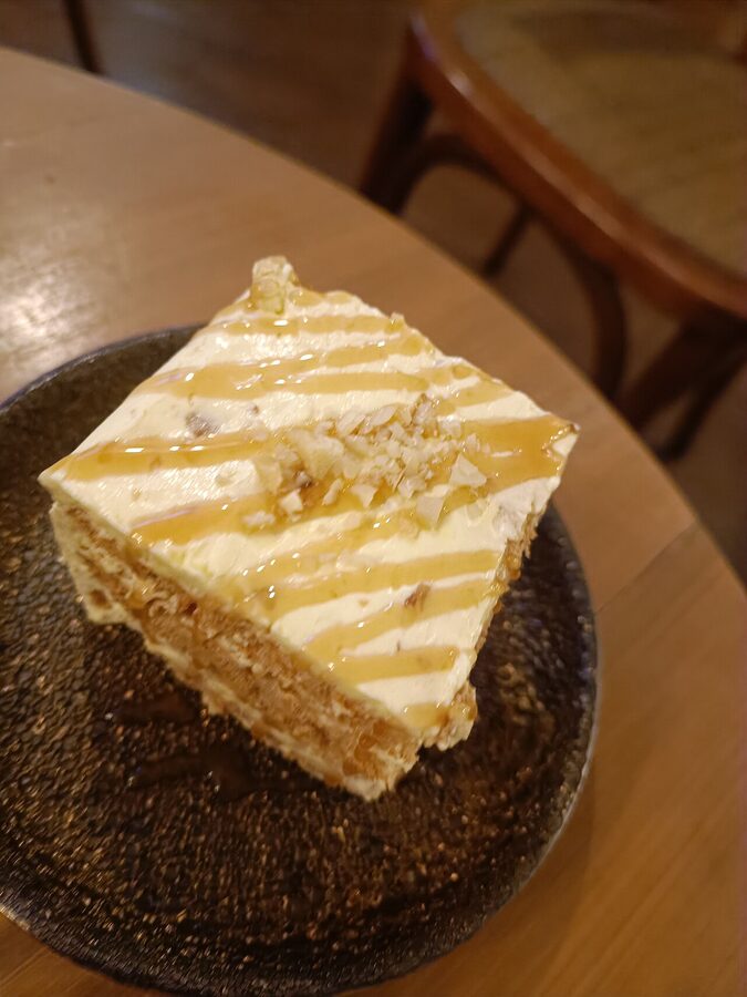 Slice of sansrival cake with cashew meringue and buttercream layers