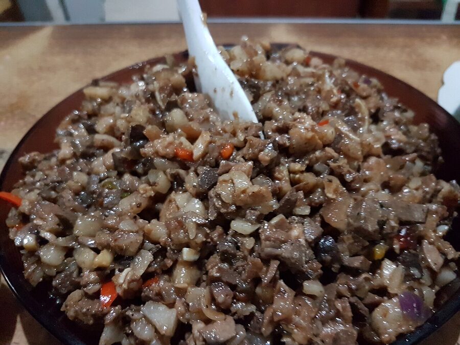 Sisig in the original Pampanga style chopped pork in a black bowl