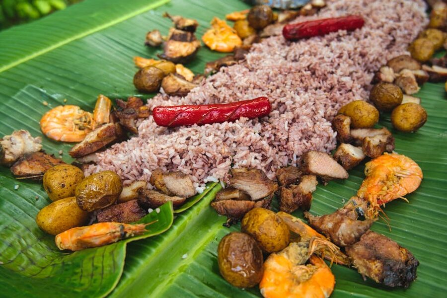 Filipino boodle fight feast spread with rice, shrimp, grilled meats and potatoes on banana leaves