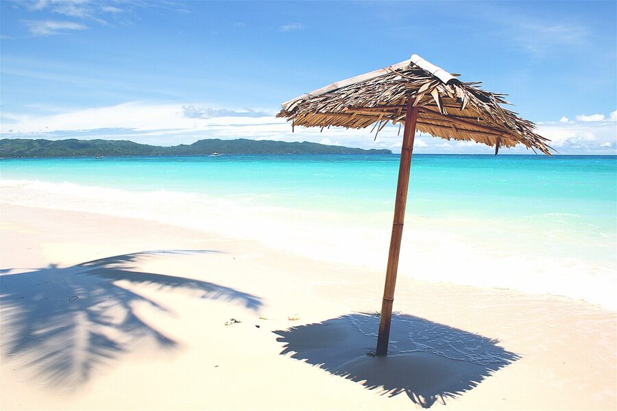 Boracay White Beach in daytime with palm umbrella and turquoise water