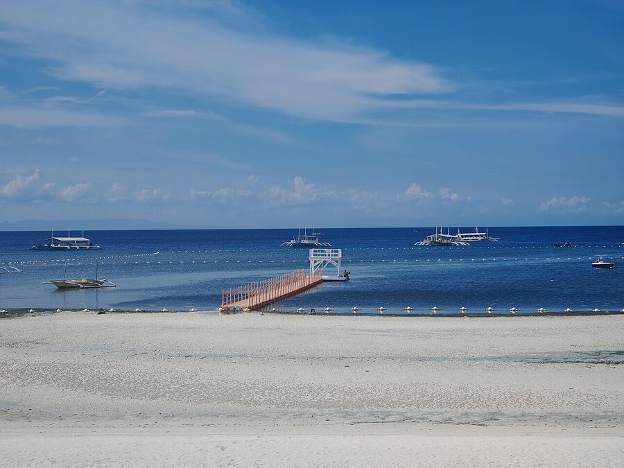 Doljo Beach Panglao with palm trees and outrigger boats